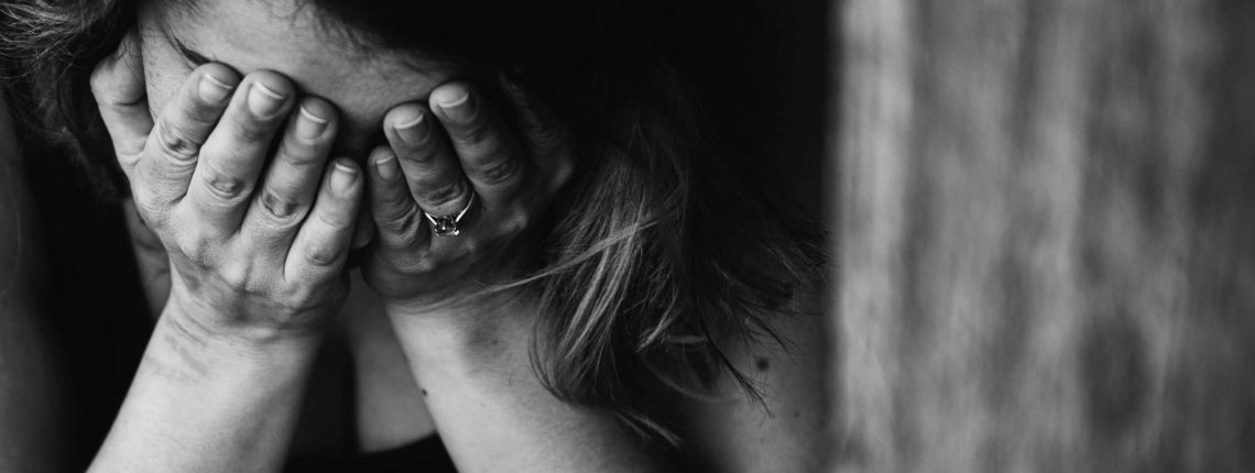 Distressed woman with head in hands